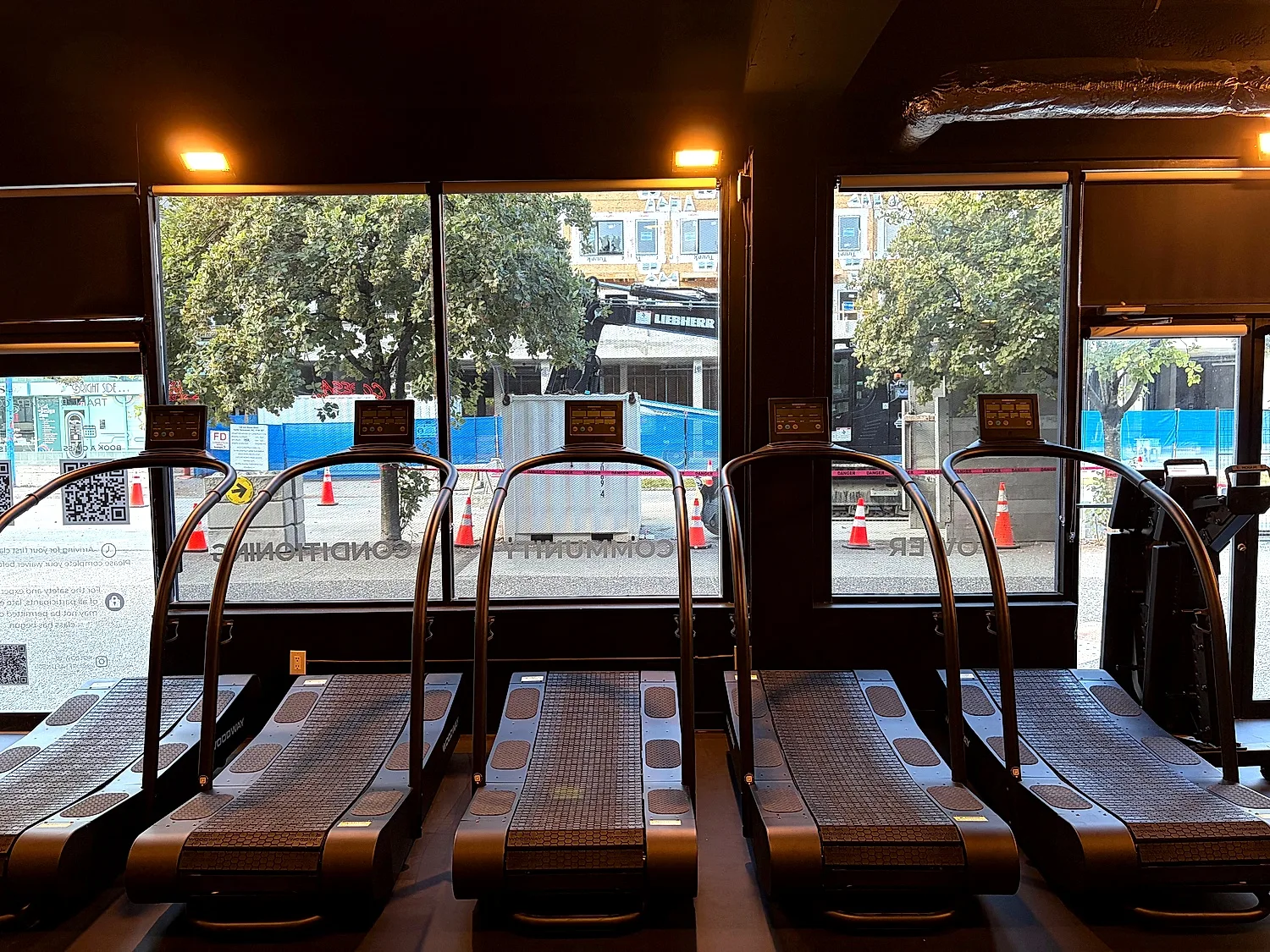 Treadmills used for HIIT classes in front of the studio windows in Lower Lonsdale
