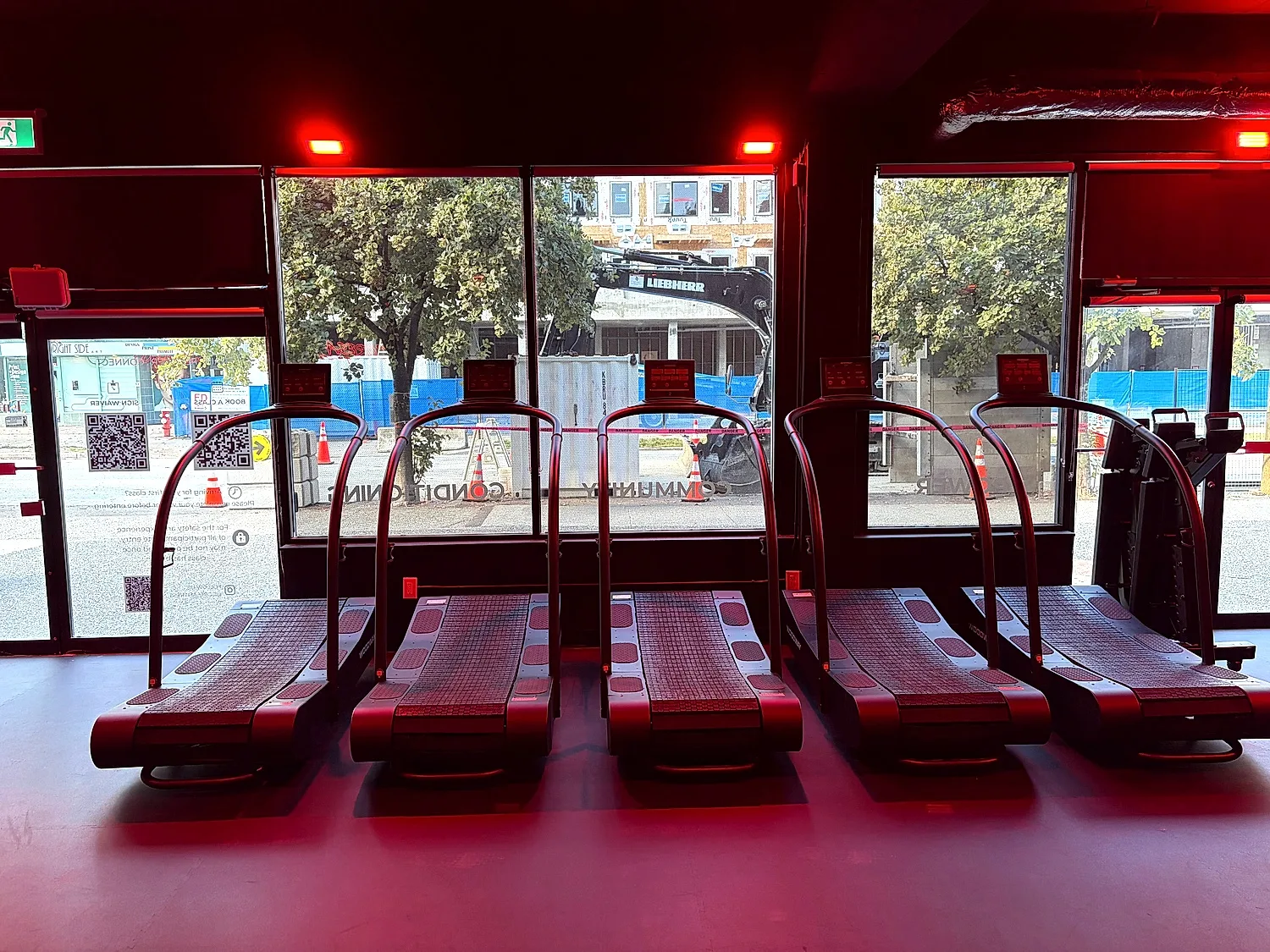 Treadmills under red lighting during HIIT classes at the Coresa studio in North Vancouver