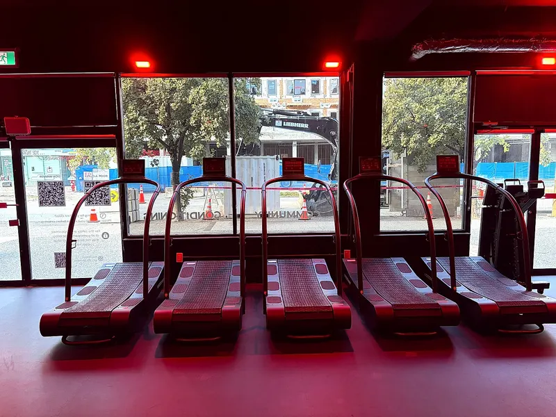 Treadmills under red lighting during HIIT classes at the North Vancouver studio