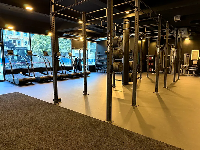 Small group training floor with squat rig, weight plates and treadmills at the Lower Lonsdale studio