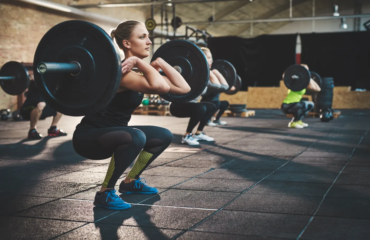 A group training together with barbells in a gym class
