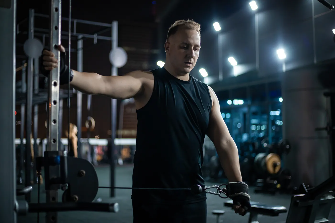 Man Doing Cable Pulldown Exercise In A Modern Gym At Night